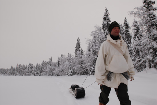 Pulling a toboggan up a river running through the boreal forest.