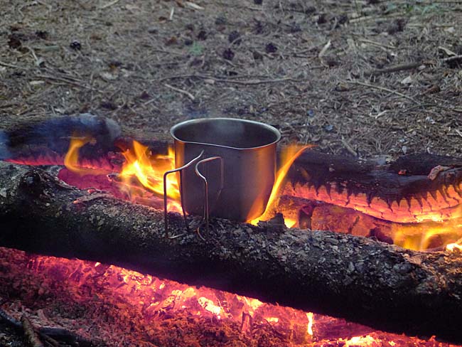 Boiling water in a metal mug on the fire