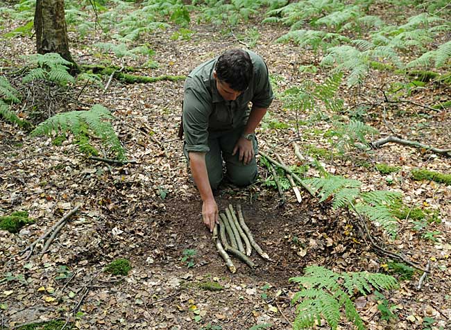 Clearing an area for a campfire and laying down a hearth