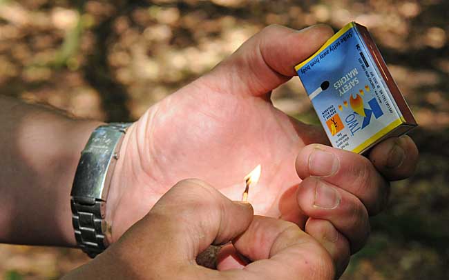 Lighting a camp fire - Cup your hands around the match