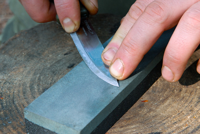 Lift the handle to maintain contact with the stone towards the tip of the knife. Photo: Ben Gray.