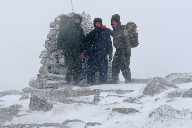 three men in the snow at the top of a mountain in Sweden