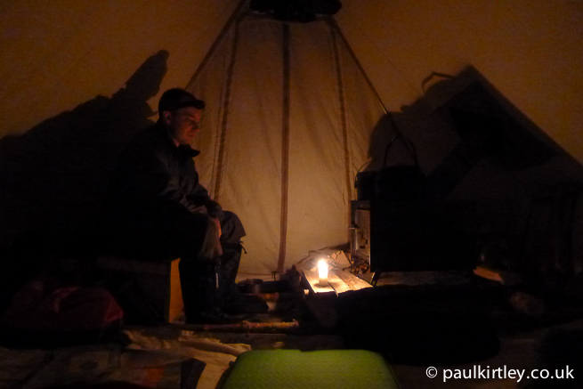 Man watching stove in a tent