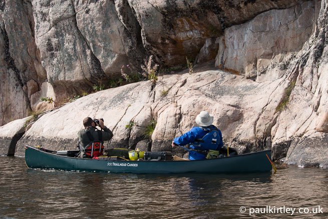 People in a canoe photographing rock art