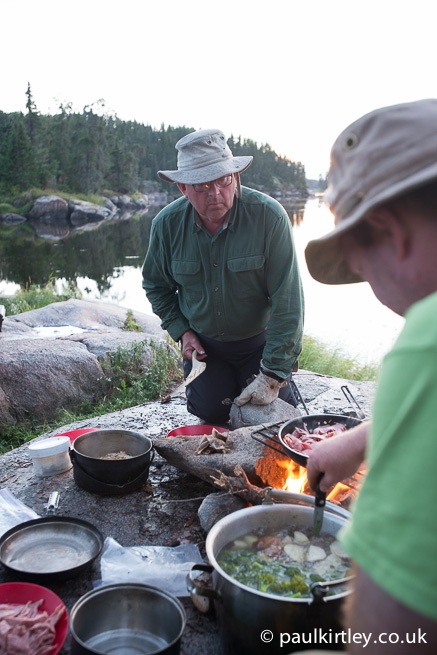 People cooking at campfire