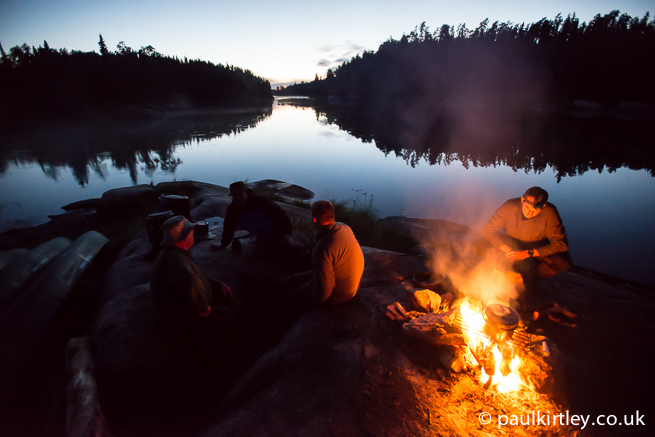 Men by a fire by a river