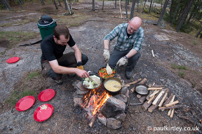 Two men cooking on a campfire