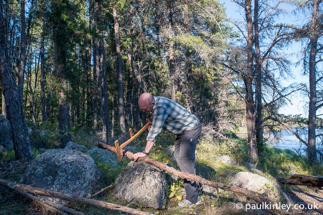 Man using bucksaw to cut timber