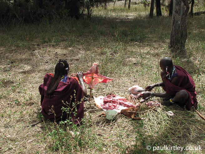Masai men preparing goat offal 