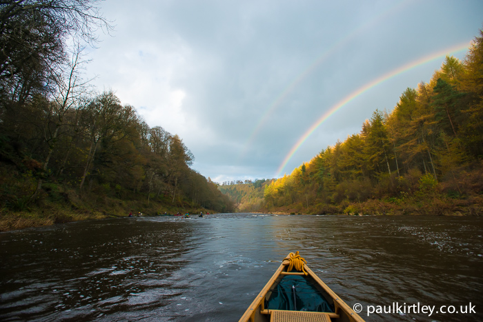 Double rainbow with river stretching into the distance and golden larches on the banks