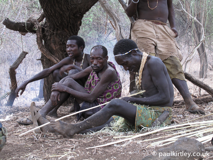Hadza hunter-gatherer making arrows for his bow