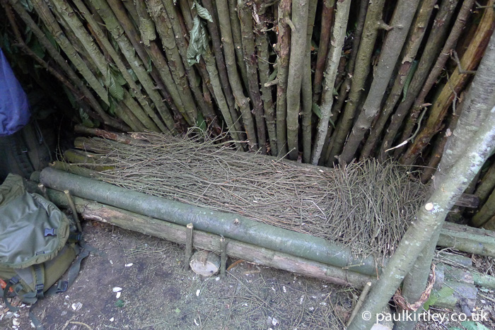 A raised log bed with dry twig mattress