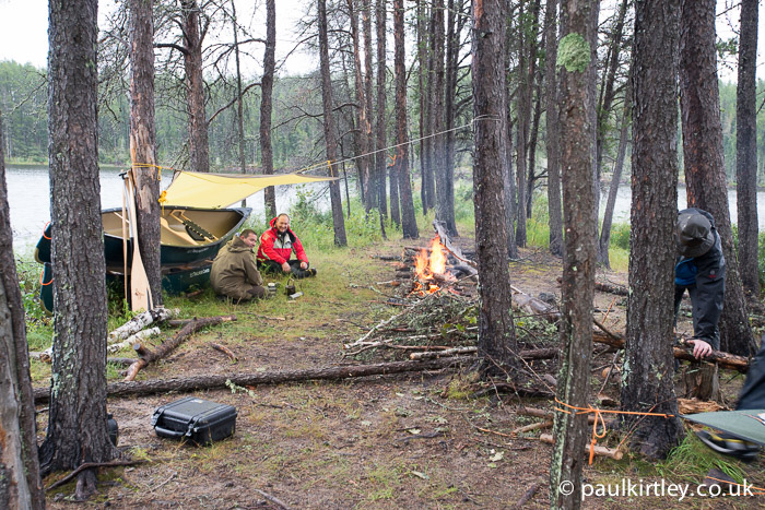 Canoes as windbreak, tarp and fire used in combination