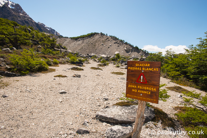 Sign ahead of the Piedras Blancas Glacier stating "Dangerous Area. Don't Proceed"