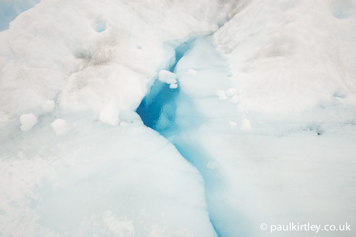 A water filled fissure in the ice of the glacier