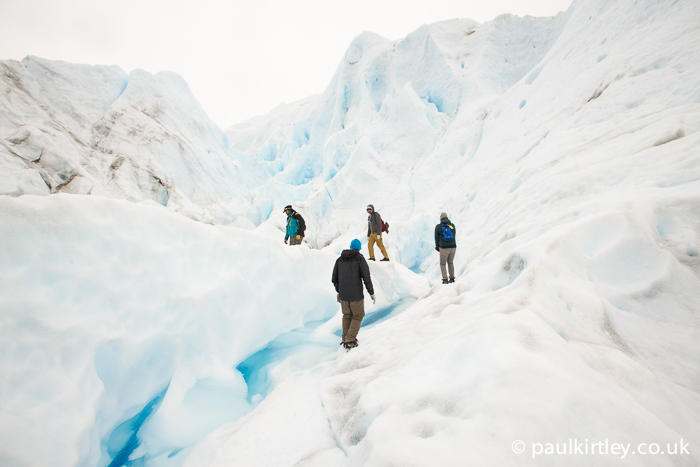 four people walking amongst serac on Perito Moreno glacier