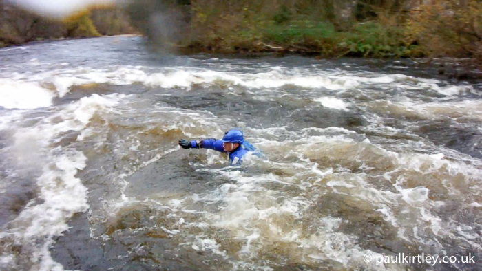 Man swimming in river rapids