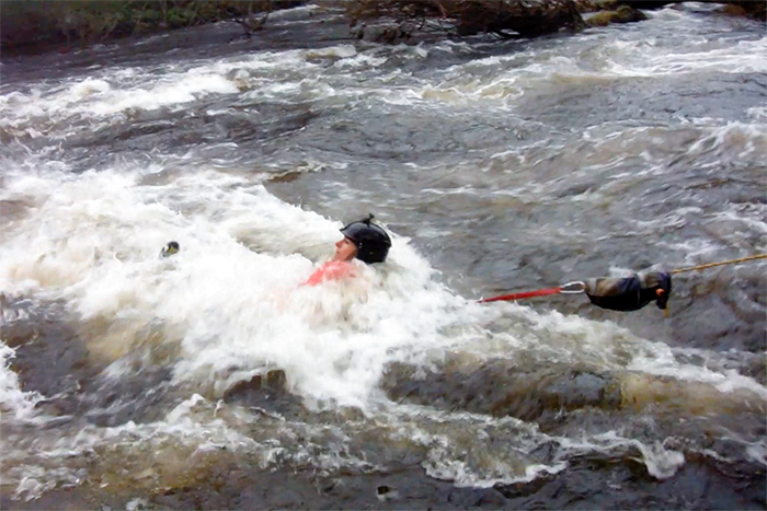 Person on rescue harness in white water