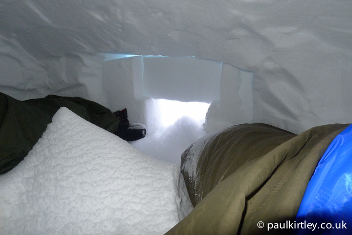 Inside a snow cave with a lot of snow blown in 
