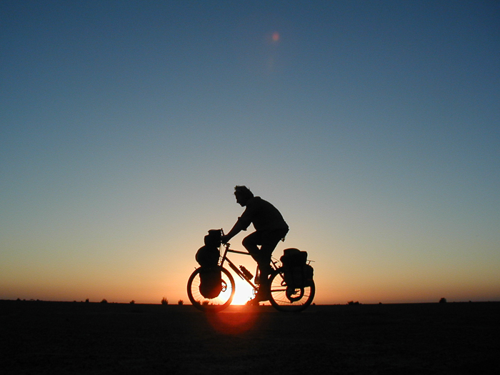 Al Humphries on a bike against a sunset