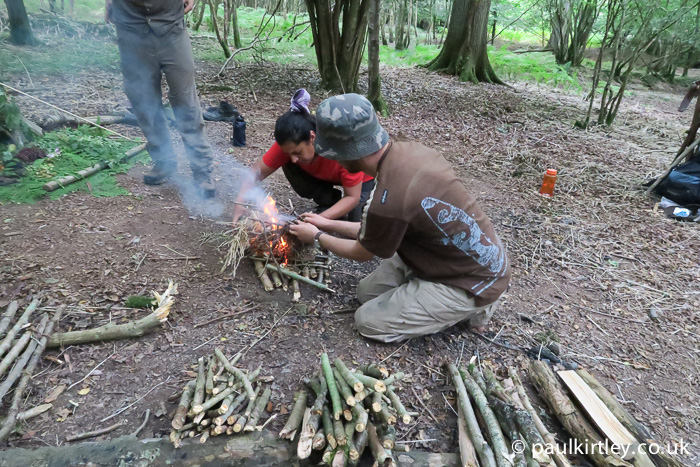 Students lighting a small stick fire