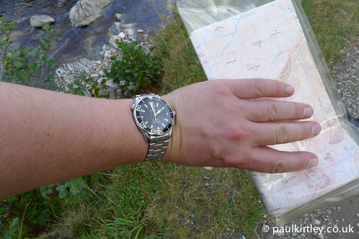 Looking at wristwatch while holding map.