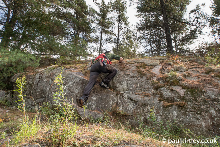 Paul Kirtley climbing up some rocks