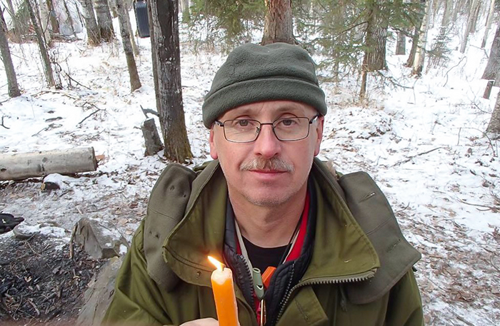 Man holding candle with snowy background