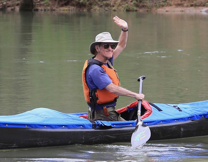 Cliff Jacobson waving from his canoe