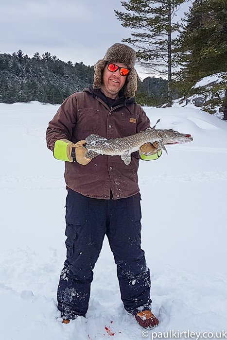Man catches pike while ice fishing