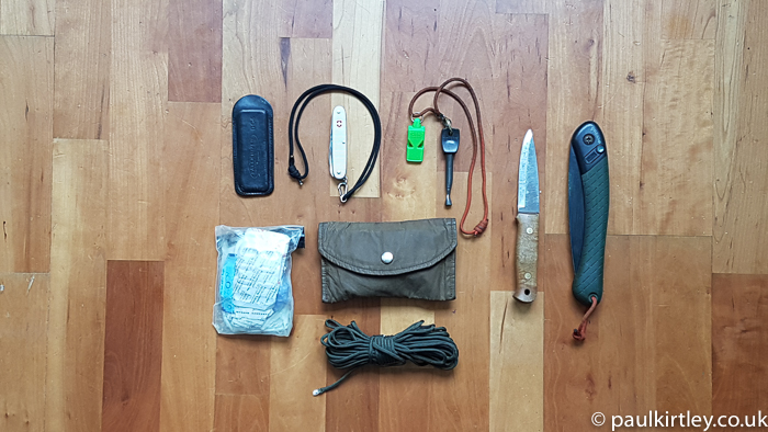 Bushcraft and survival items laid out on a wooden floor
