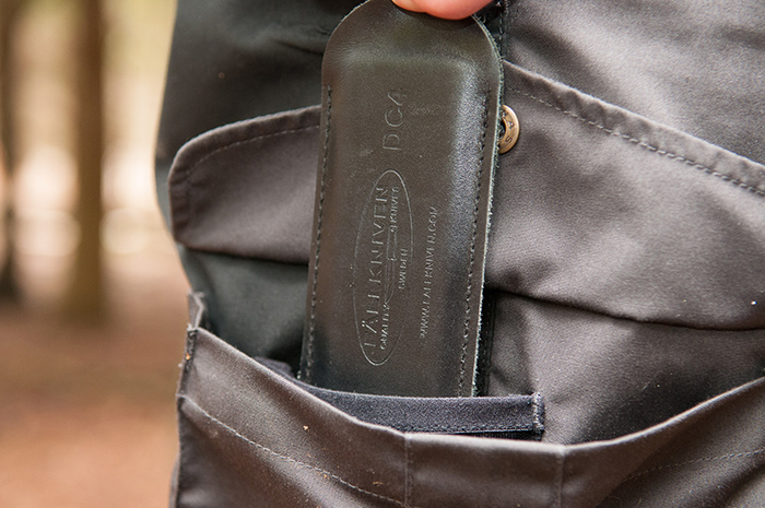 A leather slip case being put into a thigh pocket