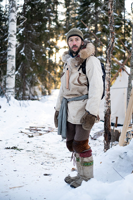 Man in cold boreal environment, wearing traditional cotton smock, wool trousers and moccasins. 