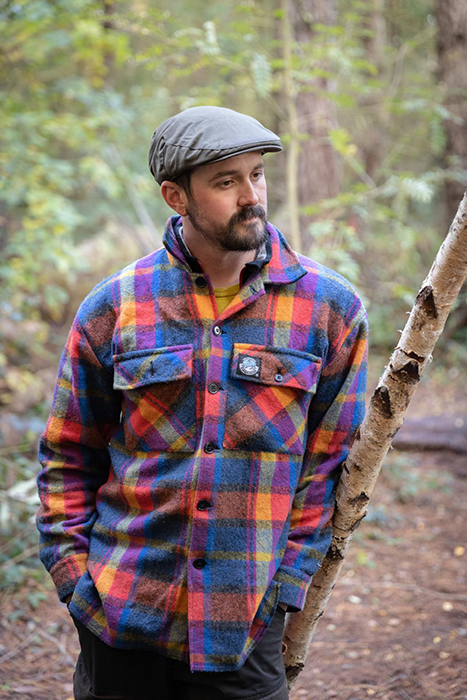 Man in flat cap and brightly coloured plaid Swandri wool shirt