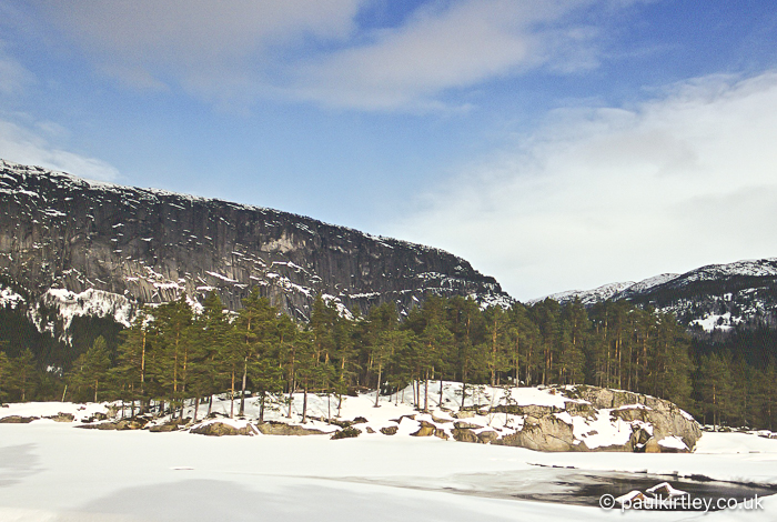 A stand of Scots pines on a rocky promontory, next to a river in Scandinavia