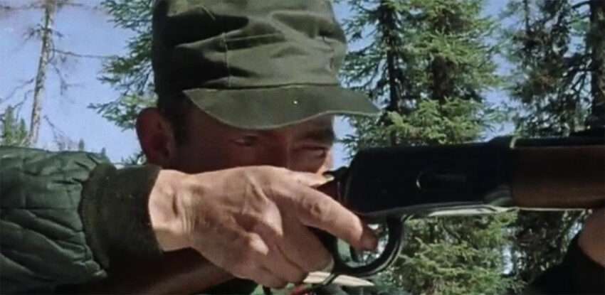 Cree man aiming rifle