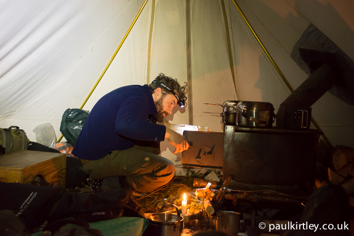 Man looking into tent stove