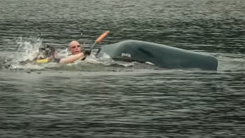 Men splashing in the water after a canoe capsize on a lake