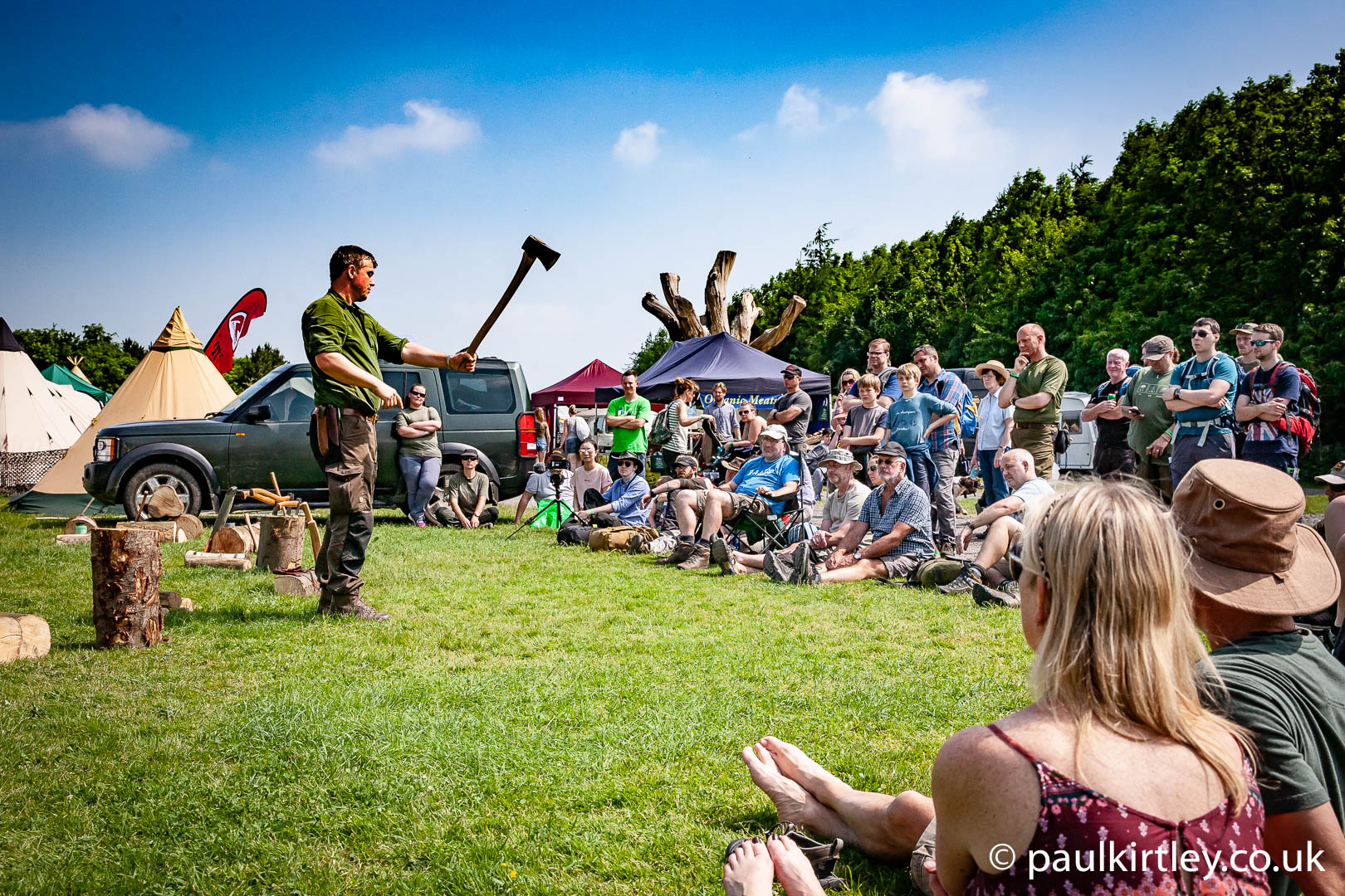 Paul Kirtley demonstrating axe skills to a gathering at the Bushcaft Show