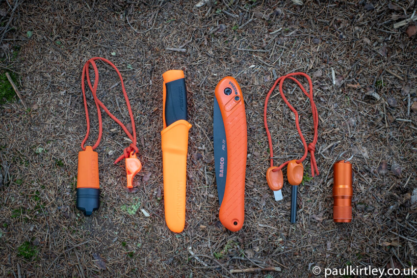 Orange lighter, whistle, knife, saw, ferro rod and match safe