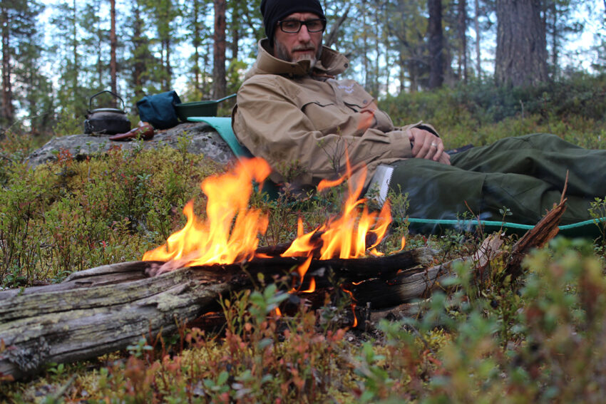 Swedish man in the forest by a small fire