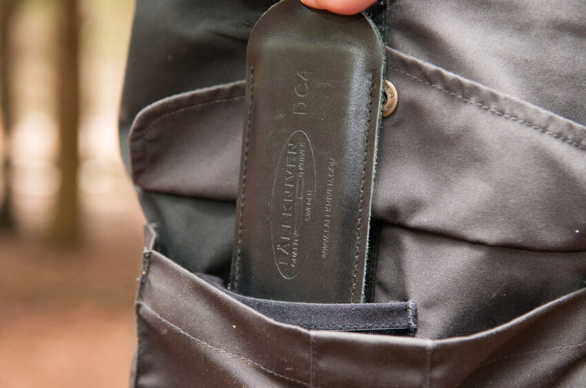 Closeup of outdoor trouser pocket with item being placed into it.