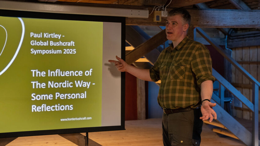 Man in checked shirt standing in front of a presentation slide titled "The Influence of The Nordic Way - Some Personal Reflections"