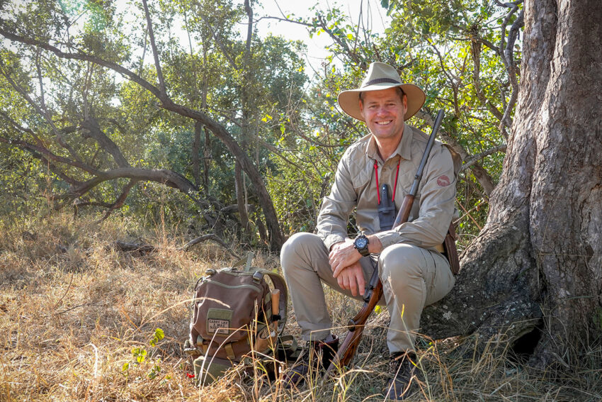 South African trails guide with backpack and rifle.